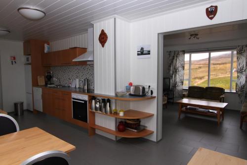 雷克霍特Guesthouse Steindórsstadir, West Iceland的厨房以及带桌椅的起居室。