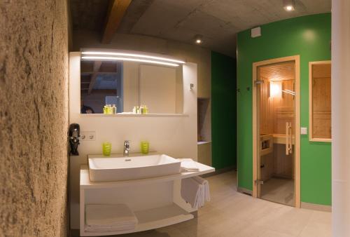 科齐扎尔滕地科隆贾尼酒店的浴室设有白色水槽和绿色的墙壁。