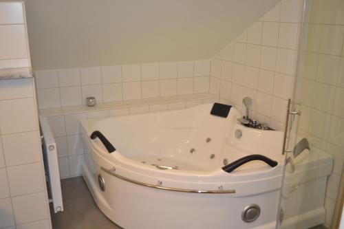 穆塔拉Hotell Nostalgi的白色瓷砖浴室内的白色浴缸