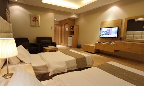利雅德Meera Suites的酒店客房设有两张床和一台平面电视。