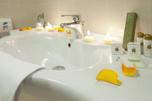 圣焦万尼泰亚蒂诺德拉纳拉餐饮酒店的浴室水槽设有蜡烛和黄色帽子