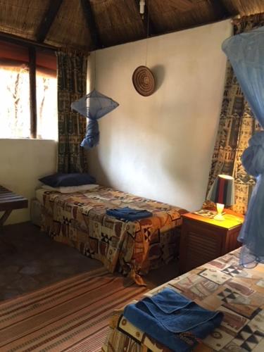 HwangeSundowner Lodge的一间卧室配有两张床和一盏灯。