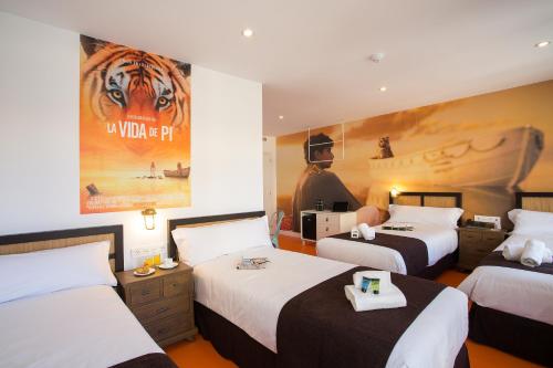 马拉加Casual del Mar Málaga的酒店客房设有两张床和一张虎海报