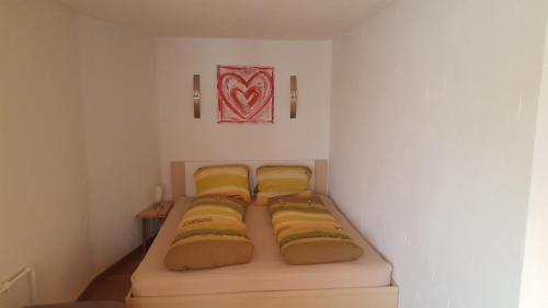 GähwilFerienwohnung Eisenring in idyllischer Umgebung的小房间设有三张床和黄色枕头
