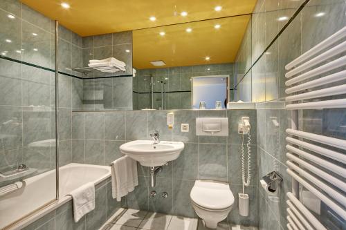 布格多夫伯克托尔德酒店的浴室配有盥洗盆、卫生间和浴缸。