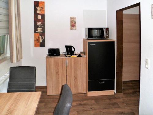 海因斯贝格Ferienwohnung Anke - Apartment 5a的一间配备了冰箱上方微波炉的客房