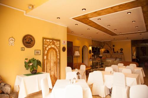 雅典加利尼宫酒店的用餐室配有白色的桌子和白色的椅子