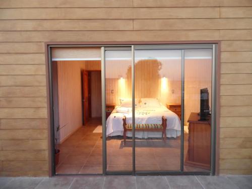 通戈伊Cabañas Urmeneta Sur的卧室设有一张玻璃门上的床铺