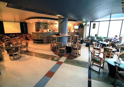 达卡La Vinci Hotel的一间带桌椅的餐厅和一间酒吧