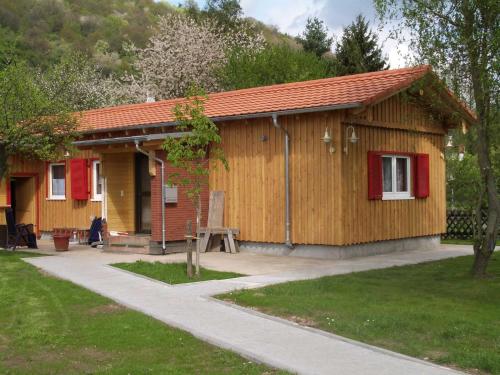NeustadtBerliner Huette的一座带红色百叶窗的小木结构建筑