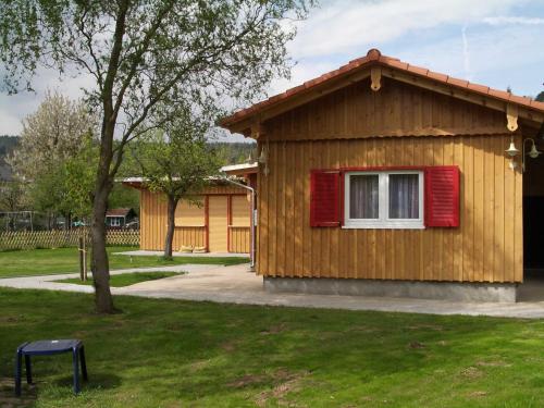 NeustadtBerliner Huette的一间设有红色窗户的小木房子
