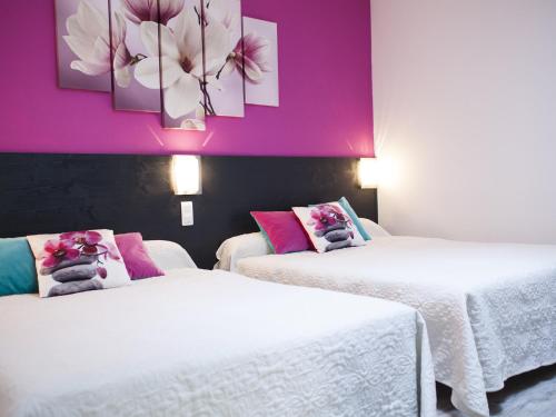 Réalville奥斯利朵酒店的紫色墙壁客房的两张床