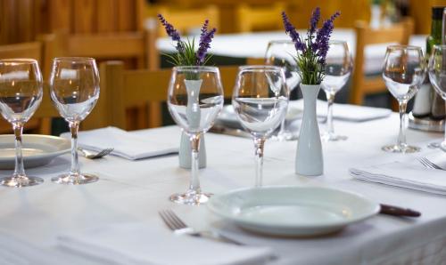巴鲁尔拉法雷阿瓦尔酒店的酒杯、盘子和紫色花的桌子