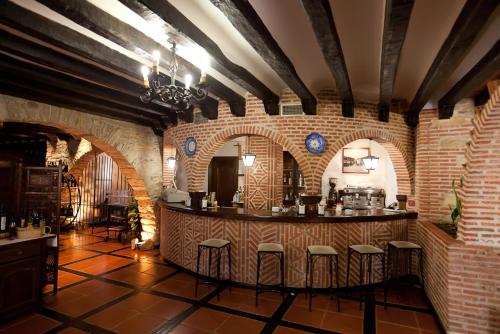 拉阿贝尔卡多纳特瑞萨酒店的砖墙间内有凳子的酒吧