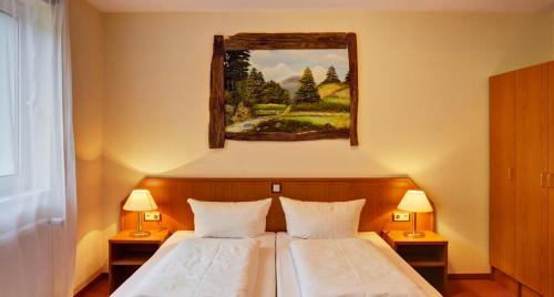 戈斯拉尔哈兹洛奇酒店的一间卧室设有两张床,墙上挂着一幅画