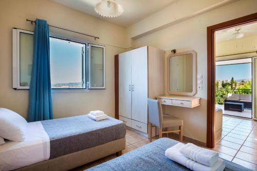 拉瑟狄奥尼索斯度假公寓的一间卧室配有两张床、一张桌子和一面镜子