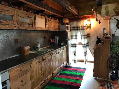 兹拉托格勒Guest Rooms Profirov的厨房配有木制橱柜和色彩缤纷的地毯。