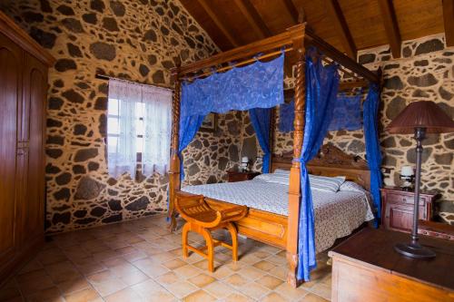 维拉韦德马奥乡村餐厅酒店的一间卧室配有一张带蓝色窗帘的四柱床