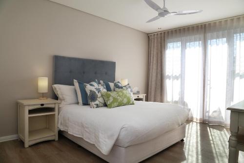 赫曼努斯Cape Coral的卧室配有带蓝色枕头的大型白色床