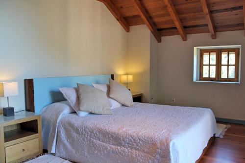 莫尼兹港OurMadeira - Casa de Campo, countryside的一间卧室配有一张带白色床单的床和一扇窗户。