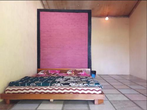 巴图卡拉苏珊民宿的粉红色墙壁的房间里一张床位