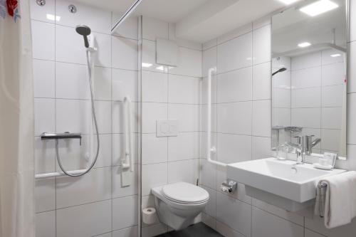 圣加仑瓦迪安加尼酒店的带淋浴、卫生间和盥洗盆的白色浴室