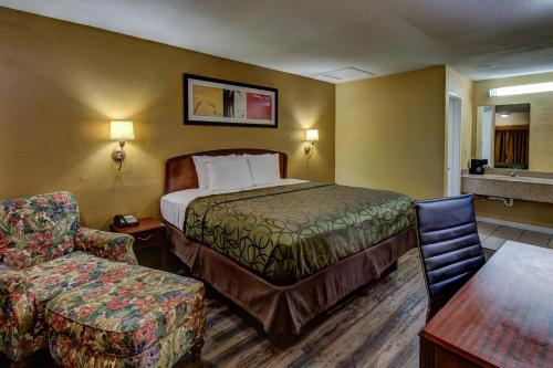 科西卡纳科西卡纳金斯威旅馆的配有一张床和一把椅子的酒店客房