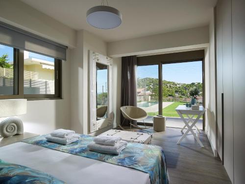 拉格尼西Elaia Luxury Suites Lagonisi的卧室配有一张床、一张书桌和窗户。