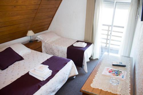 皮里亚波利斯Hotel Colón的酒店客房设有两张床和一张桌子。
