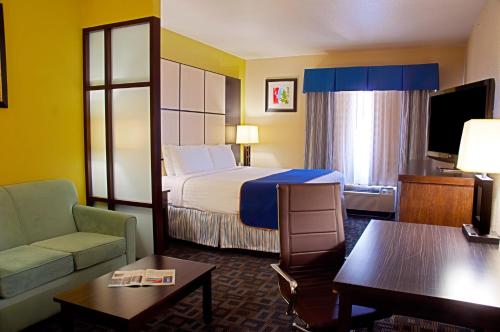 欧文DFW机场北速8酒店的酒店客房,配有床和沙发