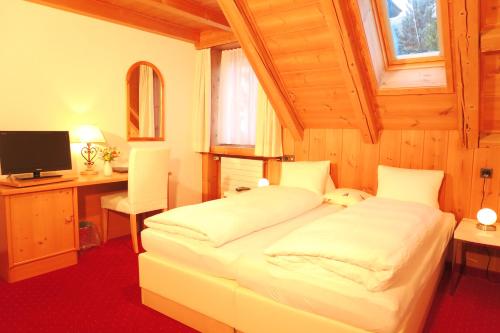 施库尔Hotel Restaurant GABRIEL的一间卧室配有一张床、一张书桌和一台电视