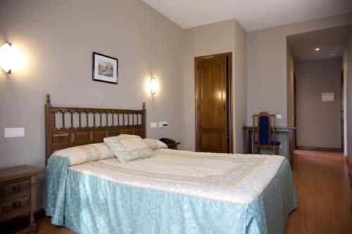 比利亚拉尔沃奥蕾莉亚之家酒店的一间卧室配有一张带蓝色毯子的大床