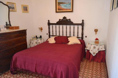 Sant Pere SacarreraCal Llorenç的一间卧室配有红色的床和两张桌子