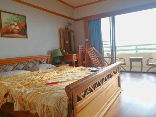 班佩罗勇市泰式风格VIP公寓的一间带大床的卧室和一个阳台