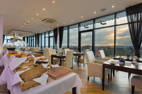 吕贝克吕贝克伽和瑞森藤维尔酒店的餐厅设有桌椅和大窗户。