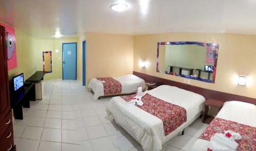 嘎林海斯港加利尼亚斯港贝拉马尔酒店的酒店客房,设有三张床和镜子