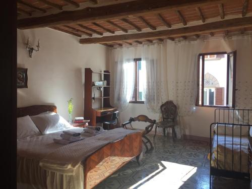 蒙特瓦尔基La Casa di Luigi的卧室配有一张床、一张书桌和窗户。