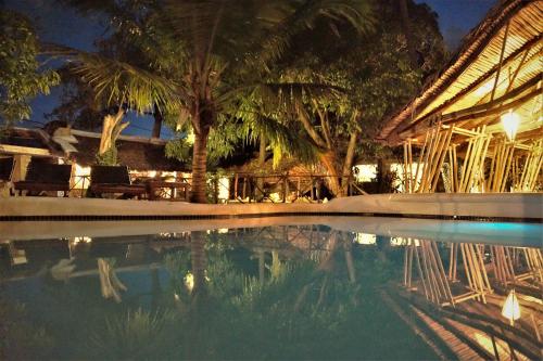 IboMiti Miwiri的棕榈树建筑前的游泳池