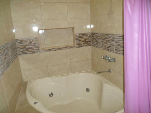 特鲁希略D´ Barrig的浴室设有浴缸,配有粉红色的淋浴帘