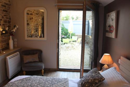 BannalecGîte de Kermal的一间卧室设有一张床和一个滑动玻璃门