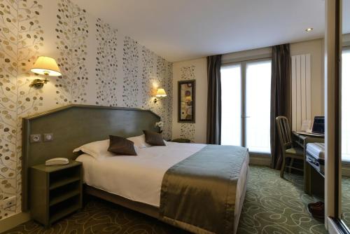 巴黎瑞拉斯杜普来酒店的配有一张床和一张书桌的酒店客房
