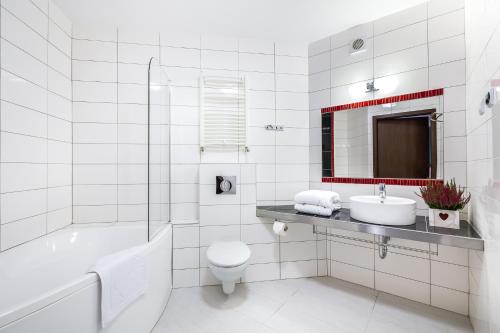 希维拉杜夫-兹德鲁伊Krasicki Hotel Resort & Spa的白色的浴室设有浴缸、卫生间和水槽。
