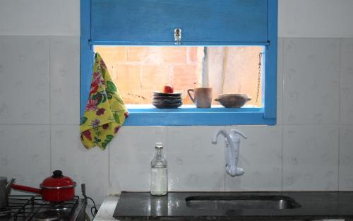 伊塔乌纳斯Arte Vida Hostel的一个带水槽的厨房和一个带碗的窗户