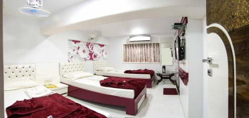 纳威孟买Hotel Pearl的红色床单的客房内的两张床