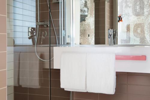 卑尔根卑尔根机场北欧之选酒店的浴室配有盥洗盆、镜子和毛巾