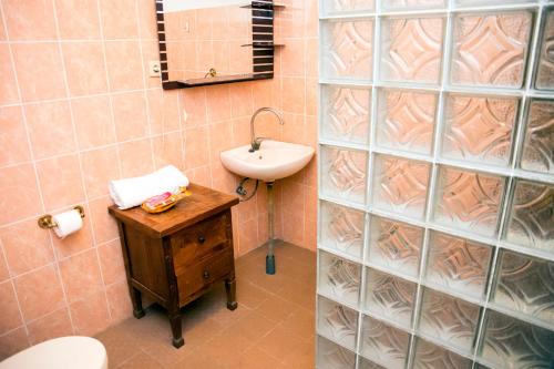帝力Casa do Sândalo Boutique Guest House的一间带水槽、卫生间和镜子的浴室