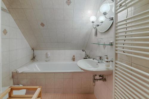 AlthüttendorfSeehotel Schorfheide的带浴缸和盥洗盆的浴室