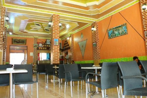 泰夫劳特Hotel Espace Tifawine的用餐室设有桌椅和橙色墙壁