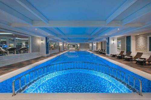 伊斯坦布尔Elite World Istanbul Florya的酒店大堂的大型游泳池,设有大型泳池导览器