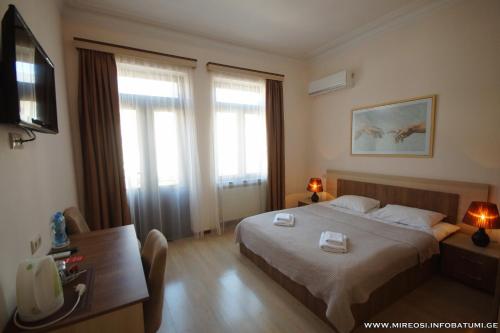 巴统米雷西酒店的酒店客房设有床、桌子和窗户。
